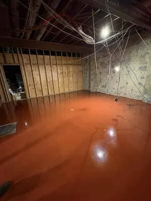 Freshly poured and finished commercial concrete floor with rust-red epoxy coating in industrial space