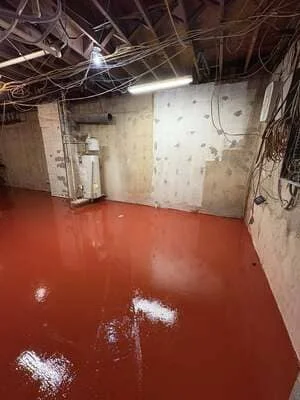 Red epoxy-coated basement floor with white accent areas in commercial space