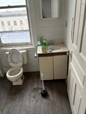Renovated bathroom with white vanity, new flooring, and updated fixtures