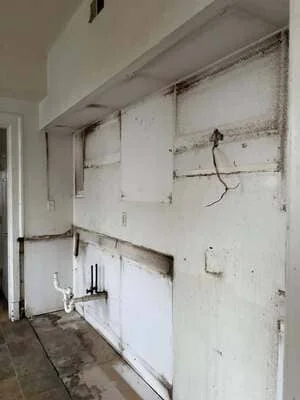 Interior wall framing with electrical conduit and plumbing rough-in during construction phase