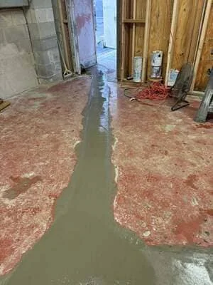 Interior space with standing water on damaged subflooring and exposed wooden door frames