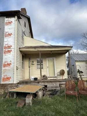 Victorian home with new vinyl siding and front porch structural repairs in progress