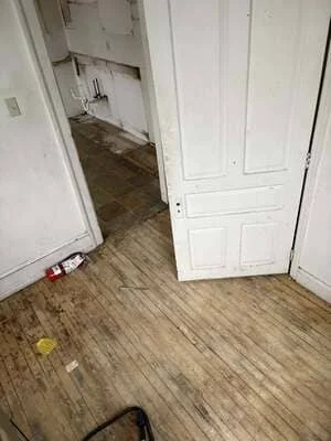 Wood-look laminate flooring installed in residential interior with white doors and painted walls